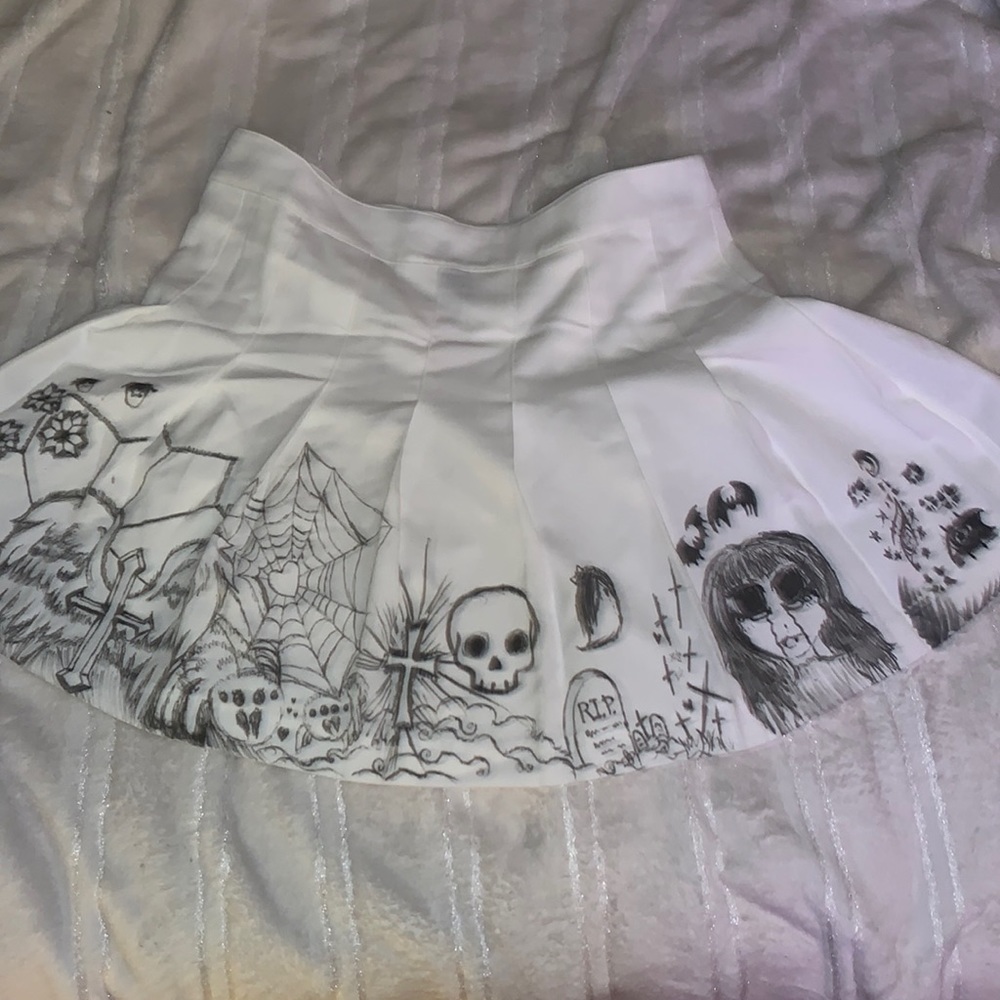 White pleated skirt with scribble on it